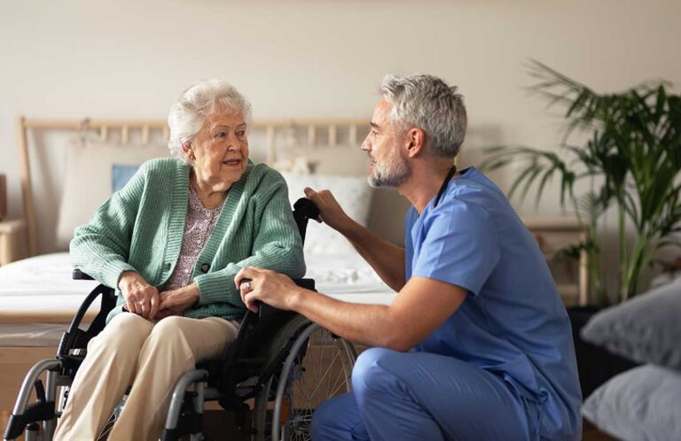 Seniors gathered around a table playing a board game and smiling together in a bright, comfortable room.